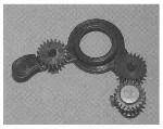 Pivot plate assembly – Three small gears, a washer, and a spring mounted on a plastic carrier – (Part of C6463A)
